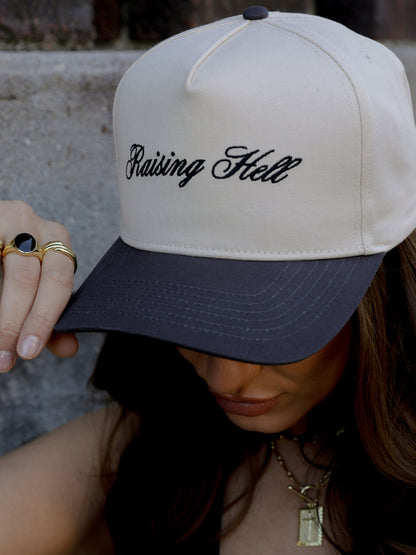 ["Raising Hell Trucker Hat ", " Charcoal/Tan ", " Model Image ", " Uncommon Lifestyle"]