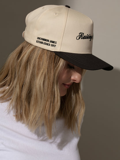 ["Raising Hell Trucker Hat ", " Charcoal/Tan ", " Model Image 3 ", " Uncommon Lifestyle"]