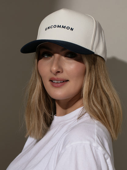 ["Simple Uncommon Trucker Hat ", " Navy/Cream ", " Model Image 2 ", " Uncommon Lifestyle"]