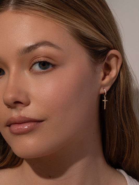 Higher Shine Cross Huggie Earrings | Gold | Model Image | Uncommon James