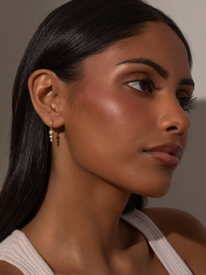 ["Moving On Arrow Huggie Earrings ", " Gold ", " Model Image ", " Uncommon James"]