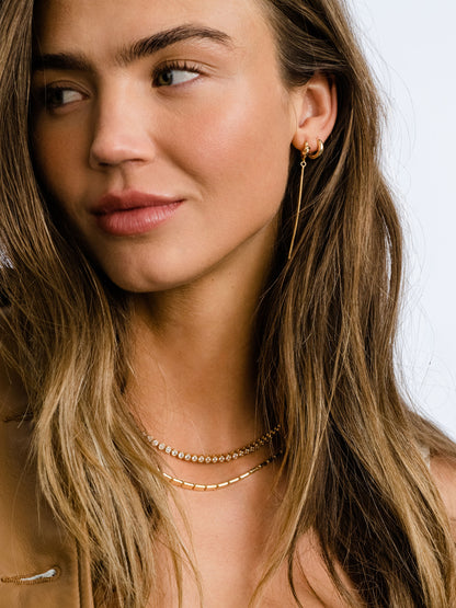 ["Forever Knot and Chain Huggie Earrings ", " Gold ", " Campaign Image ", " Uncommon James"]